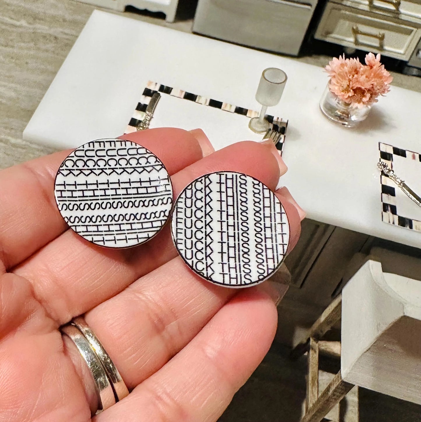 Two square \ placemats with funny dishes, white patterns held against a white background.