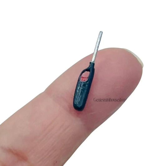 Miniature black lighter on a finger with a white background