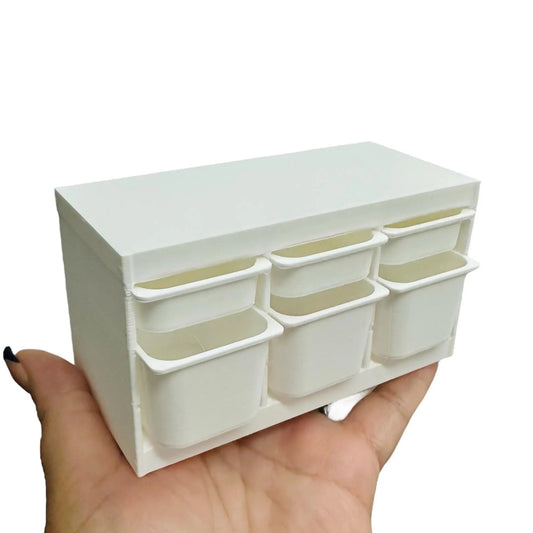 White 6 drawer storage bin with multiple small compartments held in a hand against a white background