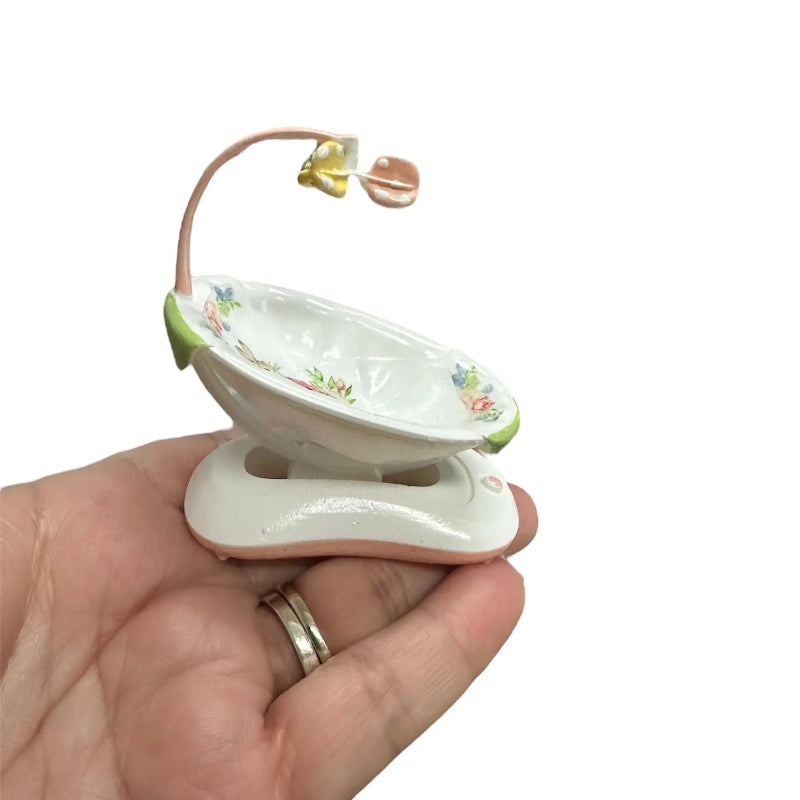 Miniature decorative baby doll swing rabbit print held in hand on a white background