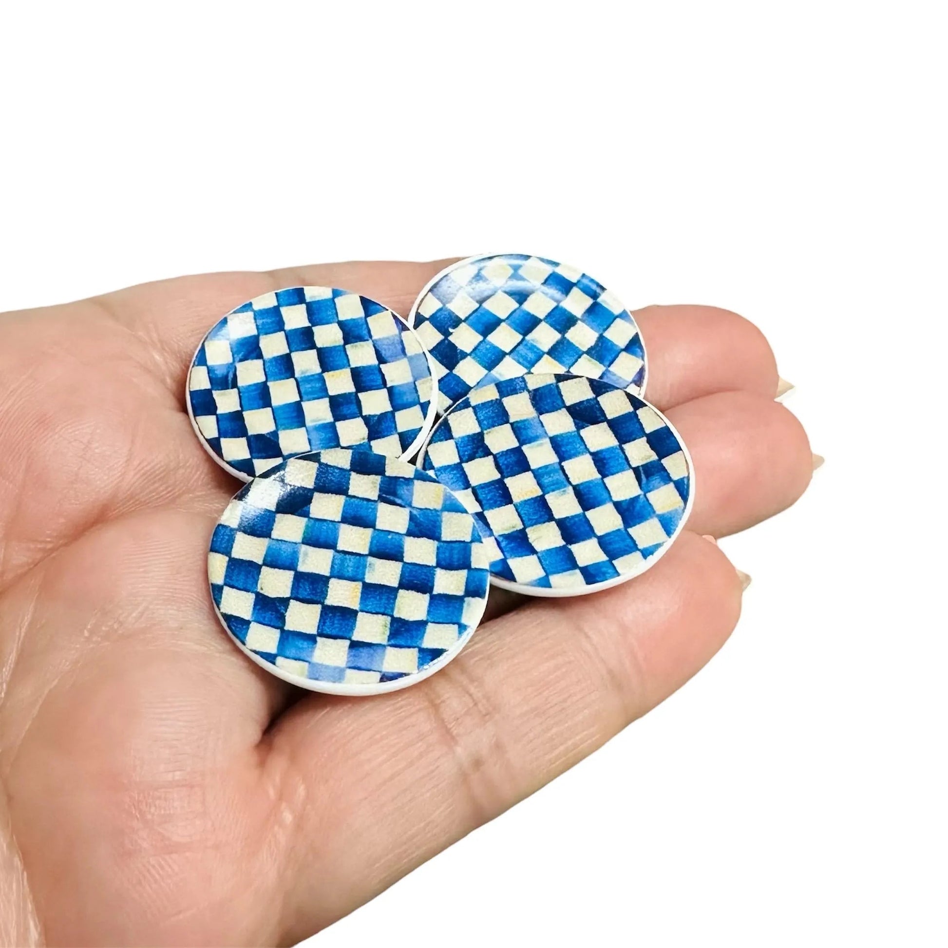 Blue and white checkered plates held in a hand against a white background