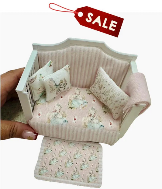 Miniature dollhouse daybed with floral patterns and cushions, held by a hand, on a white background with a red 'SALE' tag.