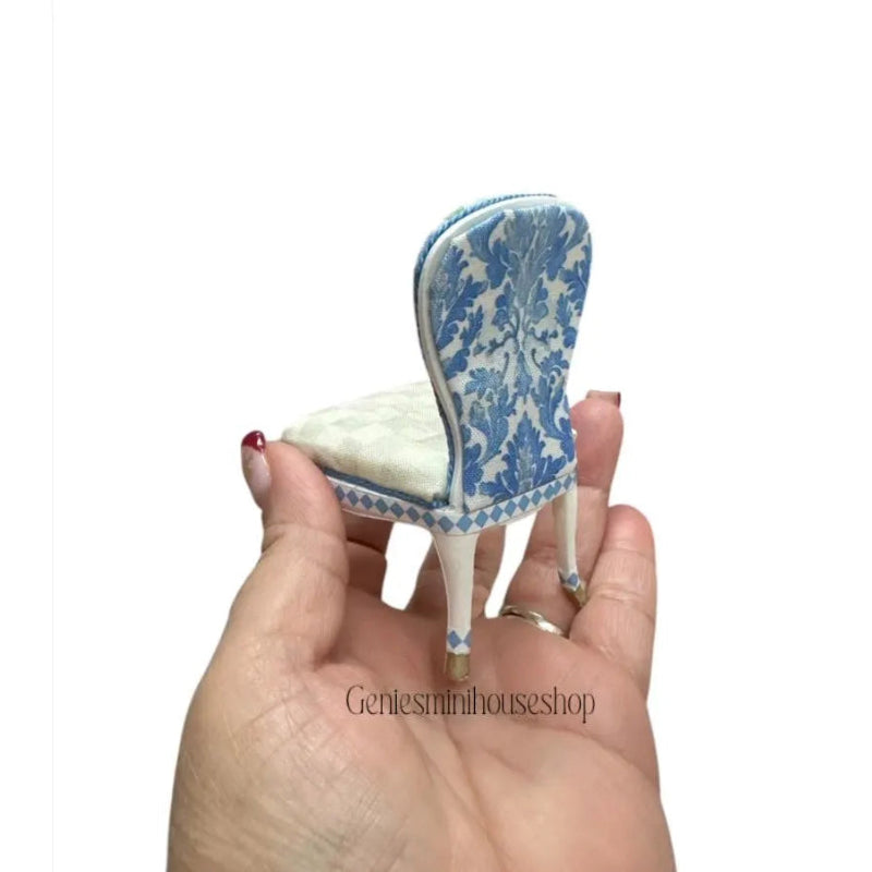 Miniature blue and white chair held in a hand with 'Gentleminihouseshop' branding.