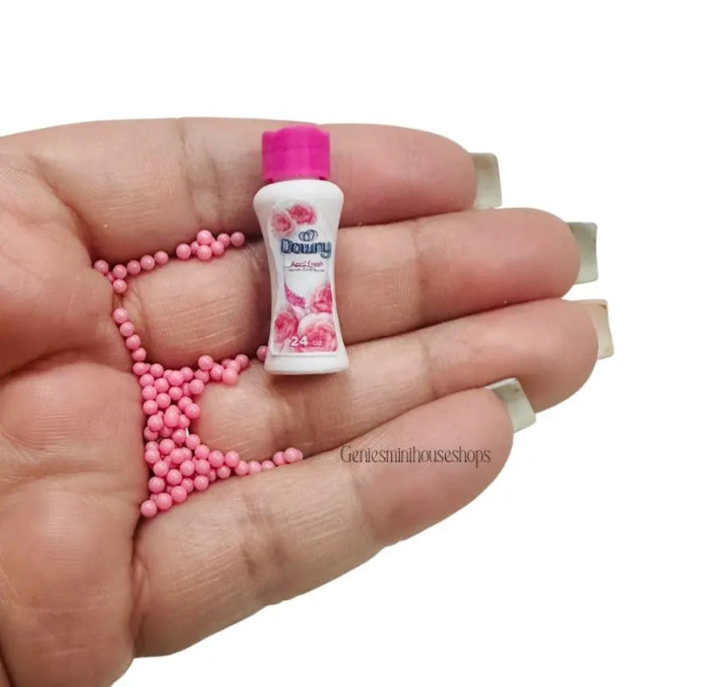 Miniature bottle with pink cap and pink beads on a hand