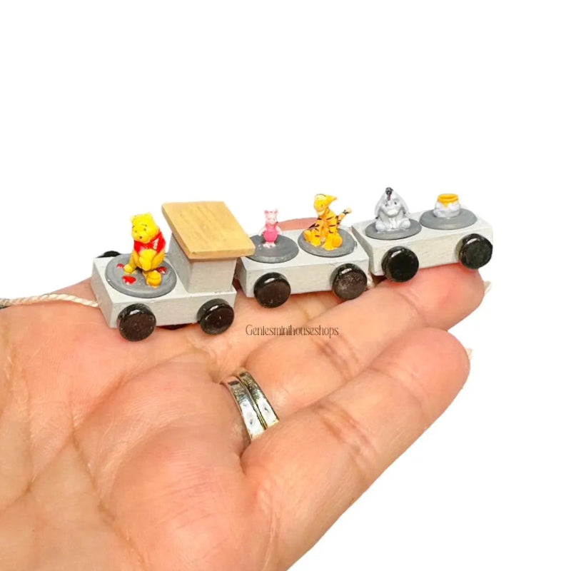 Miniature toy train set with characters on a hand