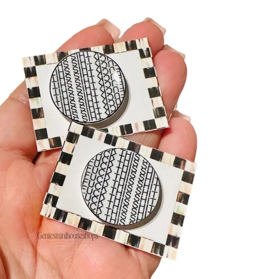 Two square \ placemats with funny dishes, white patterns held against a white background.